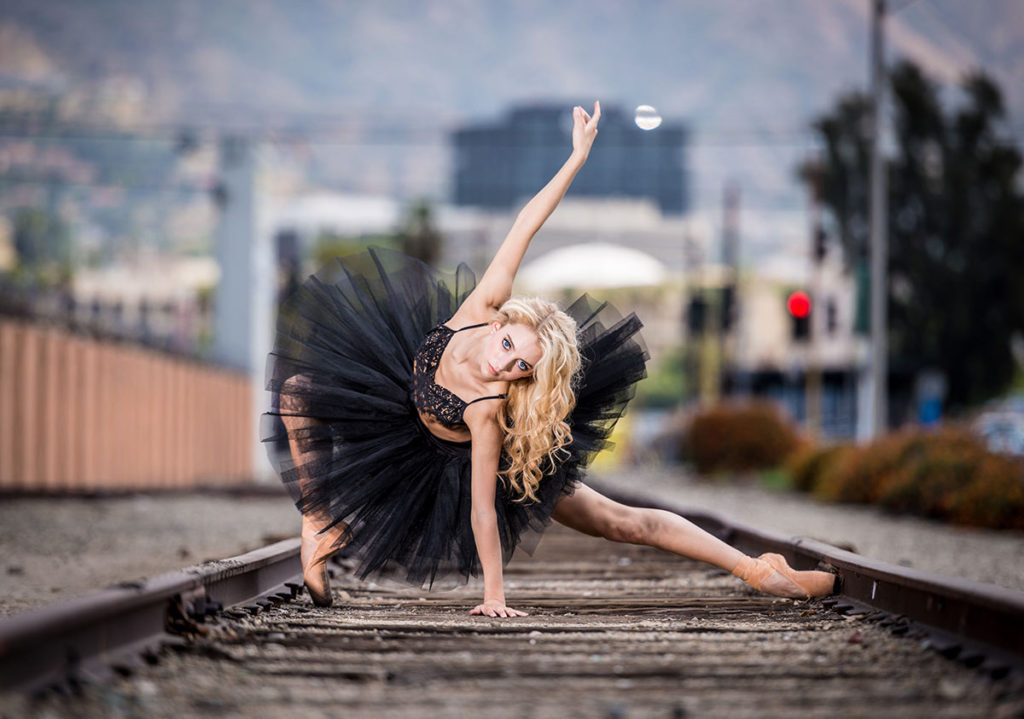 dziewczyna tańczy na torach kolejowych
